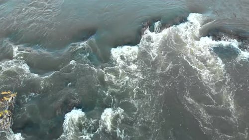 Drone Flying Low Over a Strong Stream and Flow of Mountain River, Closeup.