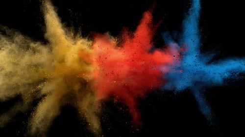 Buntes Pulver/Partikel fliegen, nachdem sie vor schwarzem Hintergrund explodiert wurden. Zeitlupe.