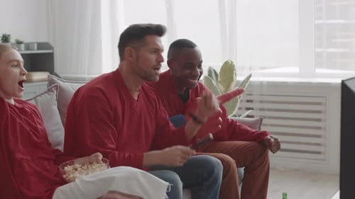Friends Cheering While Watching Television at Home