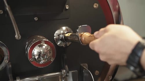 Hand Opens Valve on Coffee Bean Roasting Machine