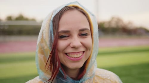 Junge Frau im Regenmantel bei Regenwetter
