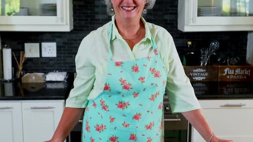 Smiling Woman Wearing Apron in Bright Kitchen