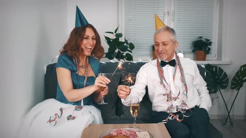 Cheerful Couple Celebrates Birthday with Sparklers and Champagne