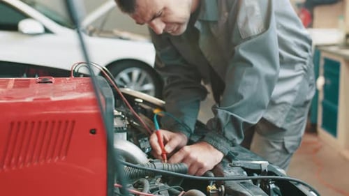 Auto Mechanic Working on Car Engine in Garage