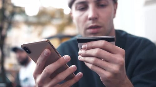 Portrait Man Buying Online Uses a Phone and a Credit Card in Outdoor Cafe Smile Shopping Cellphone