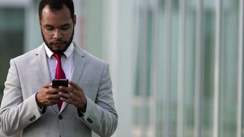 Young Businessman Using Smartphone in Urban Setting