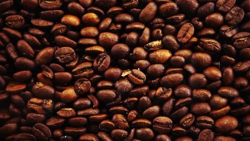 Tomber des grains de café sur fond noir.