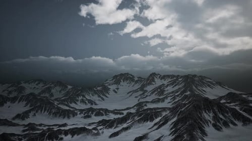 Dramatic Aerial Flyover of Snowy Mountains Under Moving Clouds
