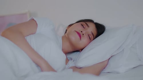 Young Woman Sleeping Peacefully in Bed at Home