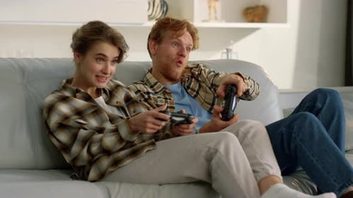 Couple Laughing and Playing Video Games Indoors