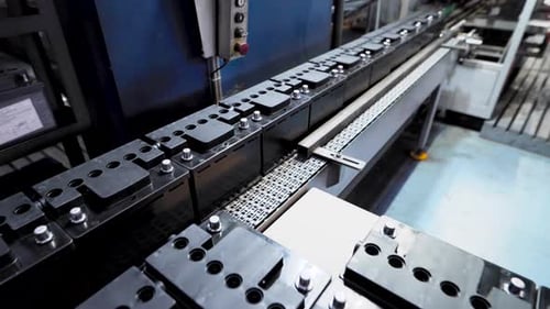 Ligne automatique pour l'assemblage de batteries de voiture. Les batteries noires se déplacent et s'accumulent sur le