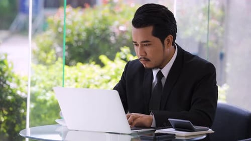 Focused Man Working on Laptop at Modern Office