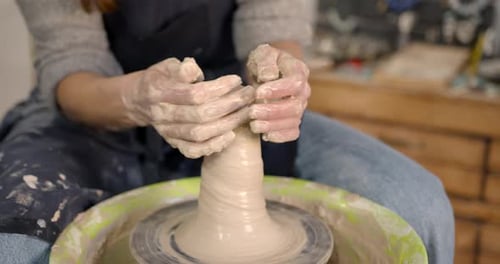 Woman Shaping Clay on Pottery Wheel in Studio