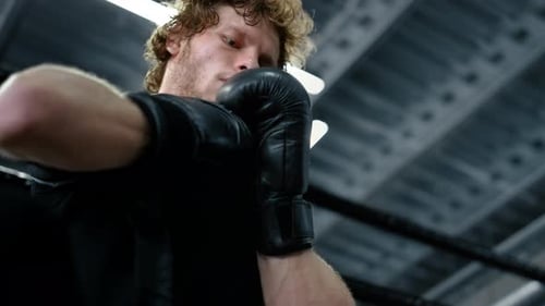 Kickboxer Putting on Boxing Gloves. Strict Fighter Hitting Hands in Sport Club