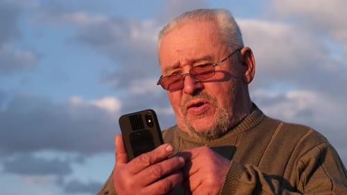 Senior Man Using Mobile Phone Outdoors