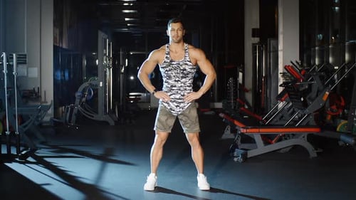 Handsome Man Lifts Hands up Leans Torso Down and Stretches Back Gym