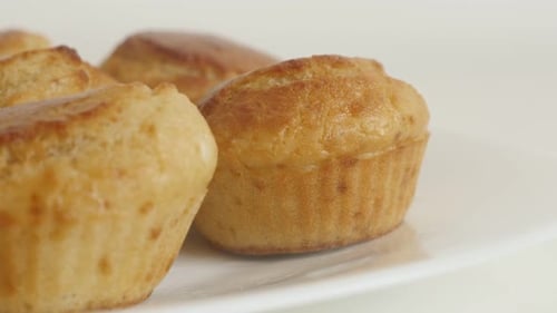 Cornbread prepared as a muffin slow tilt 4K 2160p 30fps UltraHD footage - Tasty cornmeal on white pl