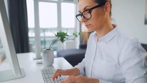 Woman Working At Computer In Home Office