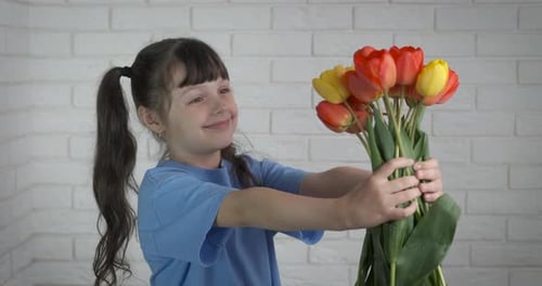 Happy Girl Holding a Bouquet of Tulips