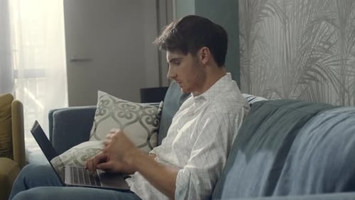 Man Typing on Laptop Computer Indoors