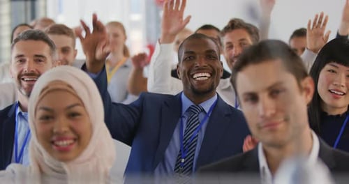 Diverse Business Group Raising Hands in a Conference