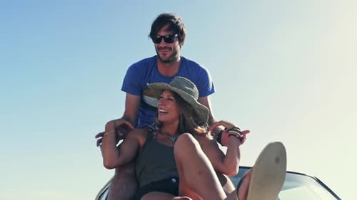Happy Couple Relaxing on Car at Beach