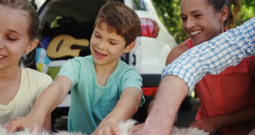 Family sitting with their dog in the park