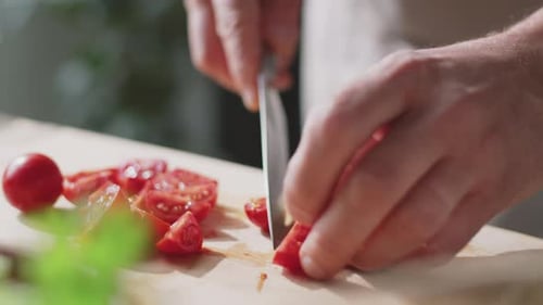 Hands Slicing Fresh Cherry Tomatoes on Board