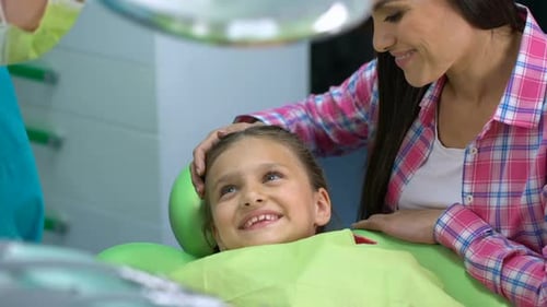 Professional Pediatric Dentist Soothing Child Before Procedure, Giving High-Five