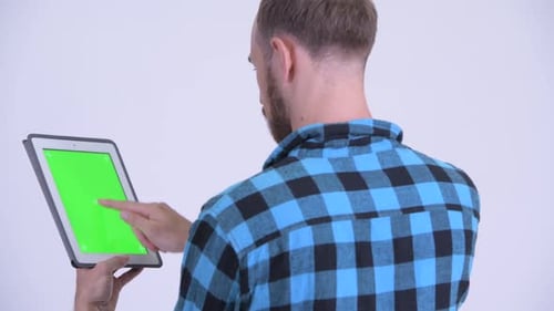 Rear View of Bearded Hipster Man Using Digital Tablet