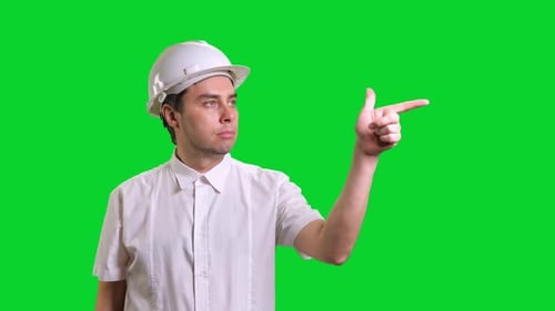 Young Male Engineer Standing and Pointing Aside on Green Screen Background
