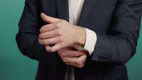 Man Adjusting Cuff on Dress Shirt