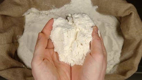 Hands Scooping Flour from Burlap Sack
