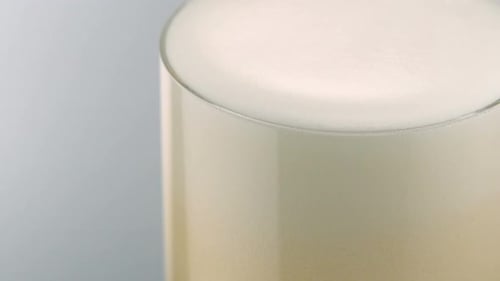 Frothy Beverage Overflowing from Glass Close Up