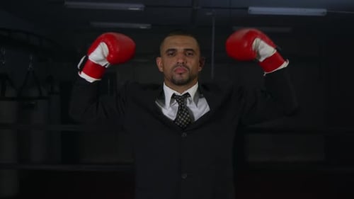 Businessman with Boxing Gloves Stands in the Ring