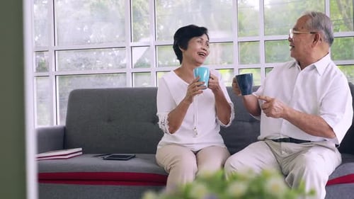 Elderly Couple Drinking Coffee Together in the Living Room