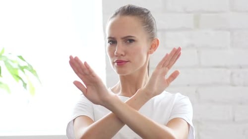 Woman Makes an X Shape with Her Arms