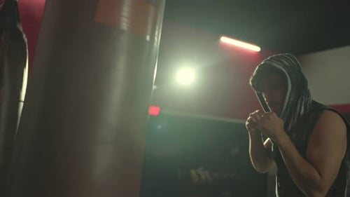 Man Boxing with Punching Bag in Gym