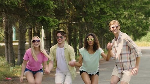 Fiesta de verano, gente feliz tomados de la mano y saltando en el parque, relajación