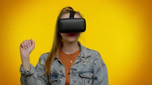 Woman Interacting with Virtual Reality Headset on Yellow