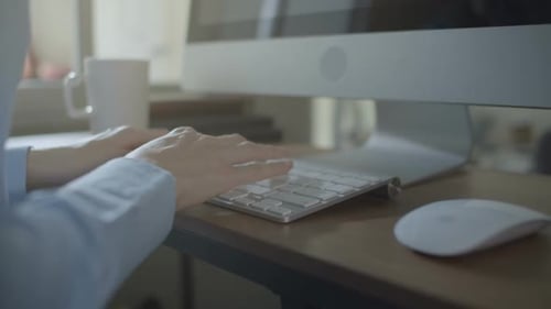 Close Up Hands Typing on Keyboard at Desk