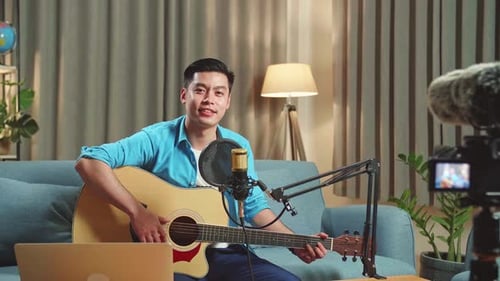 Young Man Plays Guitar for Online Video