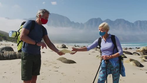 Couple on Beach with Masks Consults Map