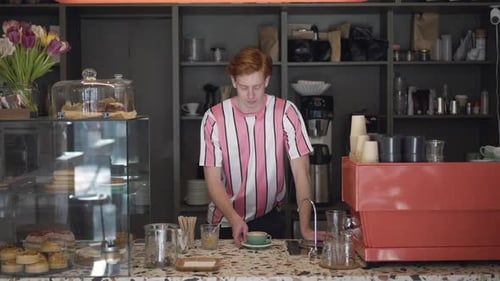 Smiling Barista Stands Proudly in Bright Cafe