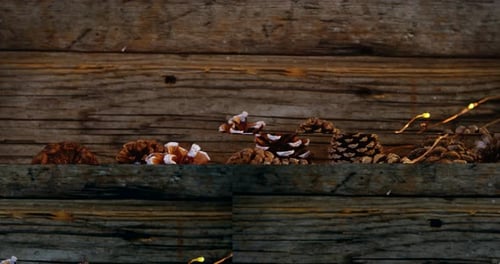 Pine Cones and Twinkling Lights on Rustic Wood