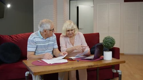 Senior Couple Checking Calculating Bills Bank Loan Payment Doing Paperwork Discuss Unpaid Debt Taxes