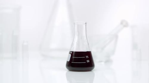 Panning view of beaker with liquid in it