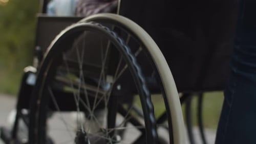 Close Up of Wheelchair Rolling on Outdoor Path