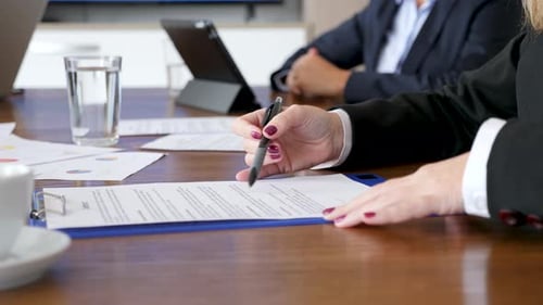 Business Woman Signing a Contract at Meeting