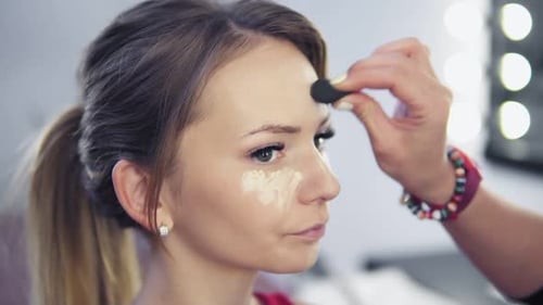 Young Woman Getting Makeup Applied in Studio